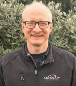 Mobile Automotive Technician and owner of Driveology Limited, pictured in black jacket bearing the company logo.